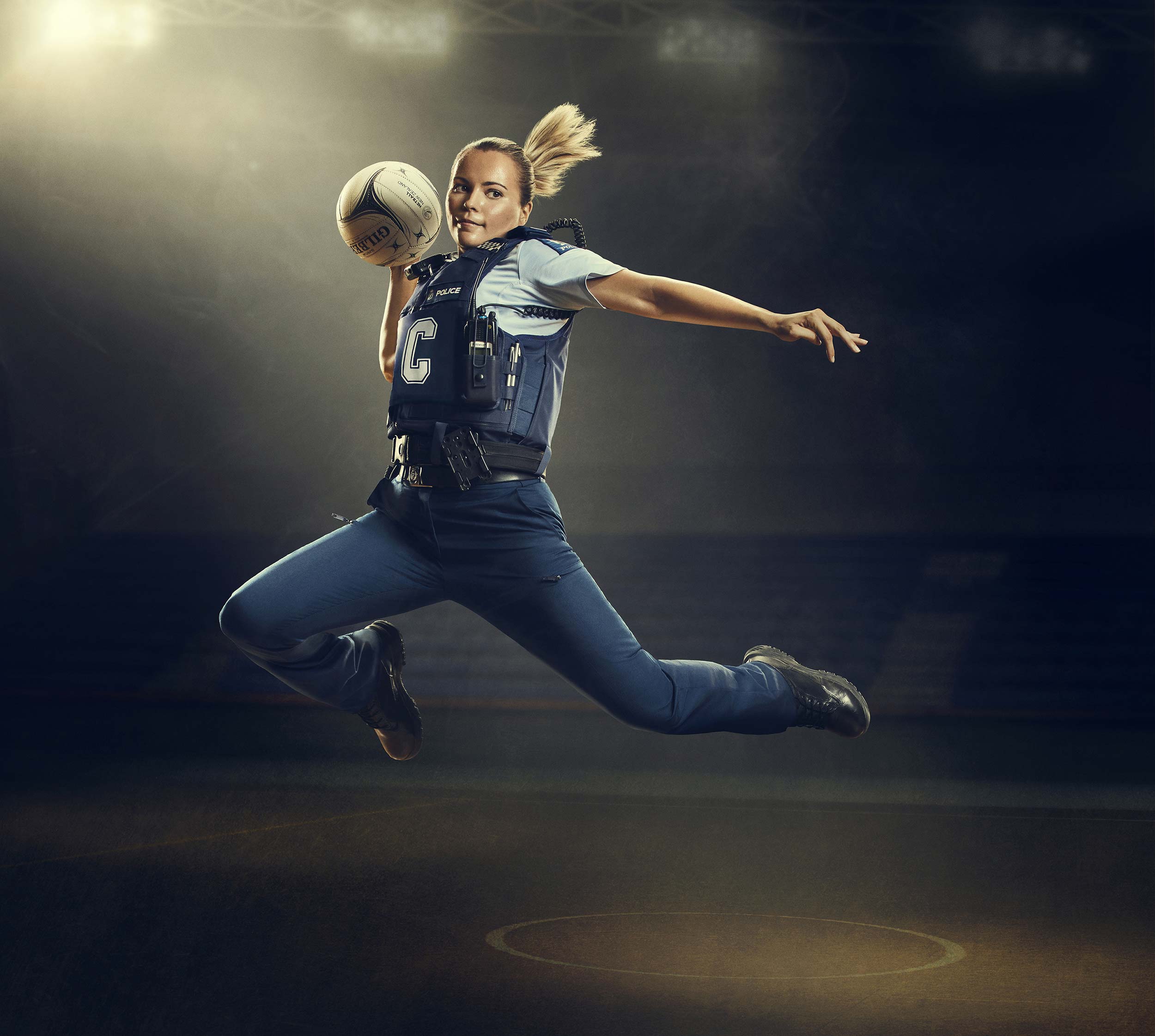 Netball player in police uniform throwing ball