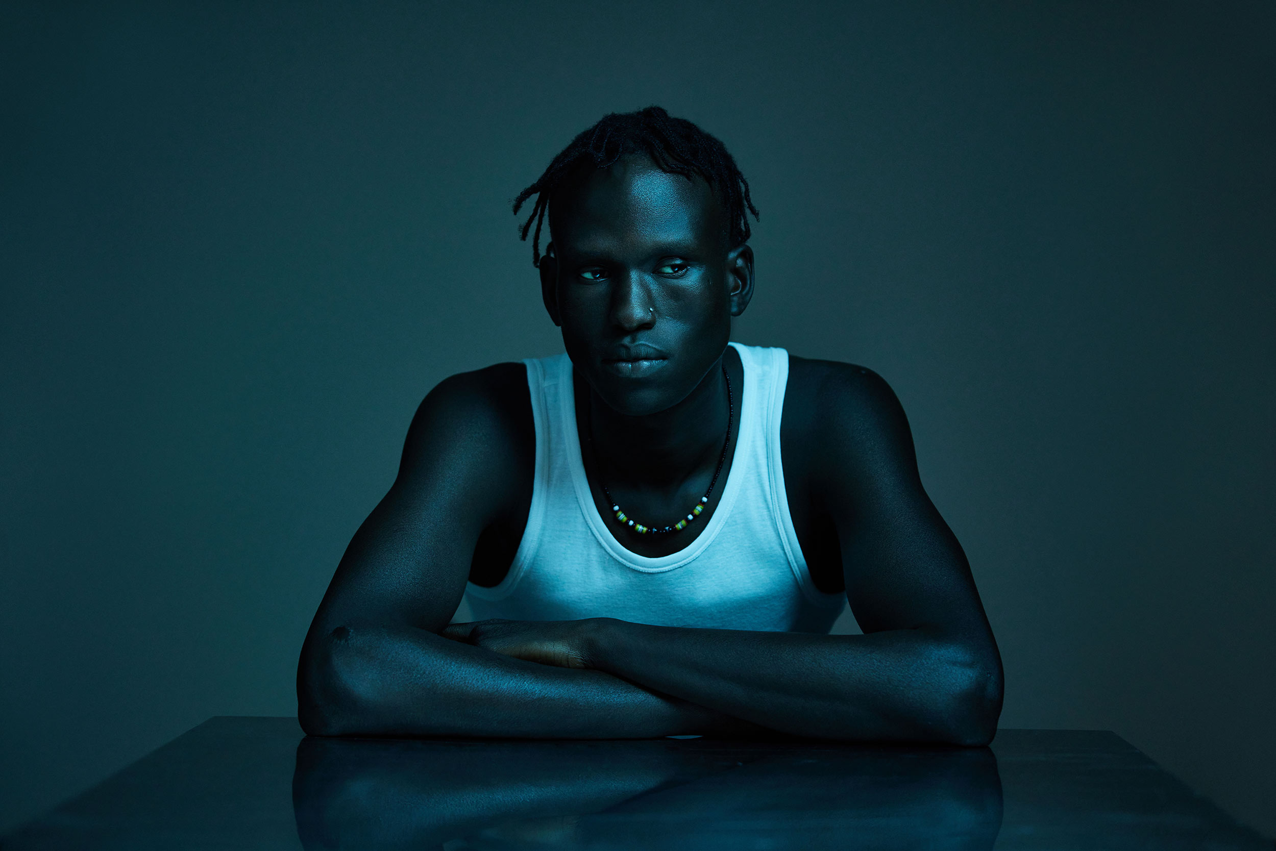 Studio black man white singlet crossed arms Jima