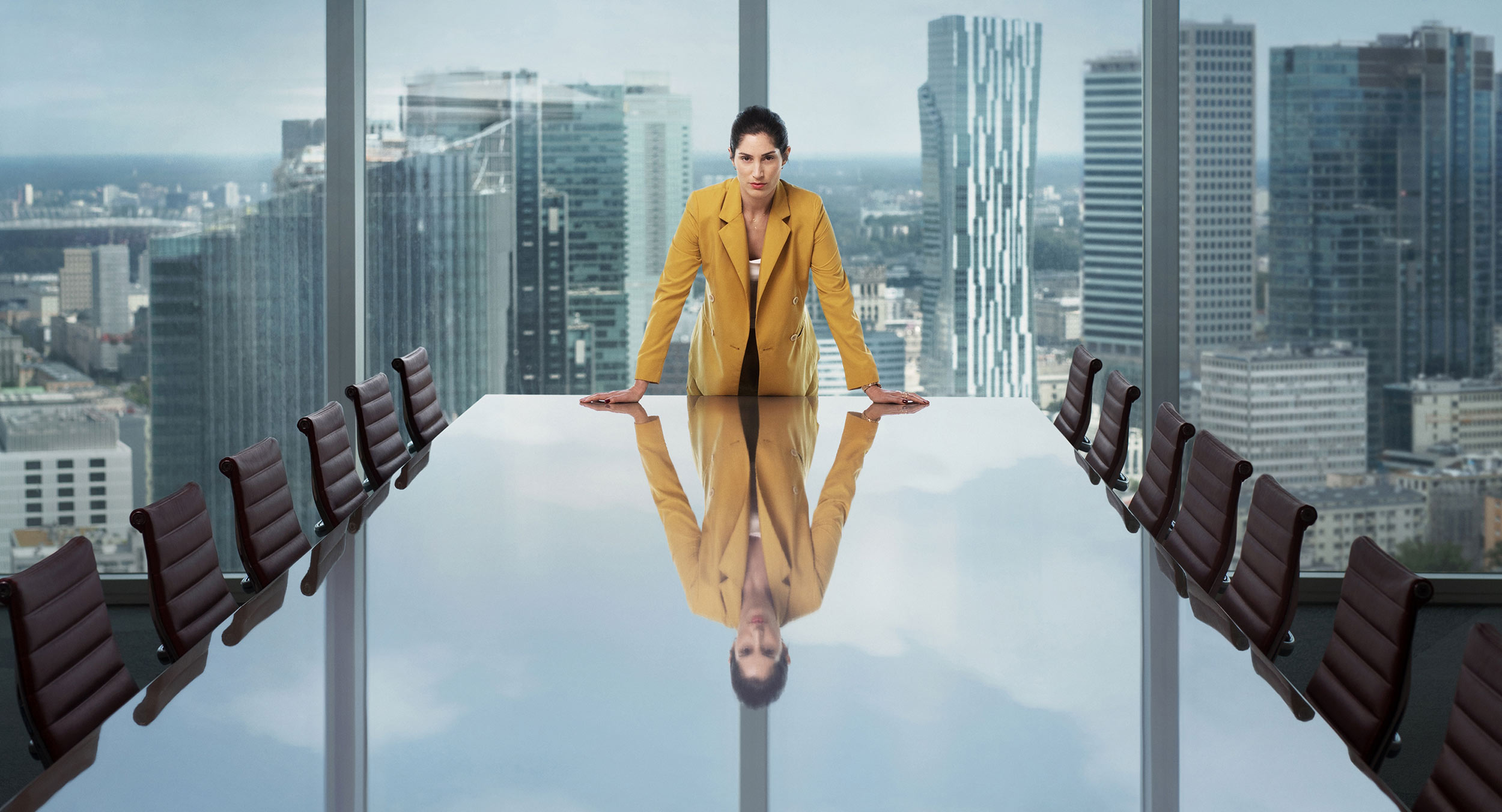 Woman in boardroom table in yellow suit Warsaw Poland