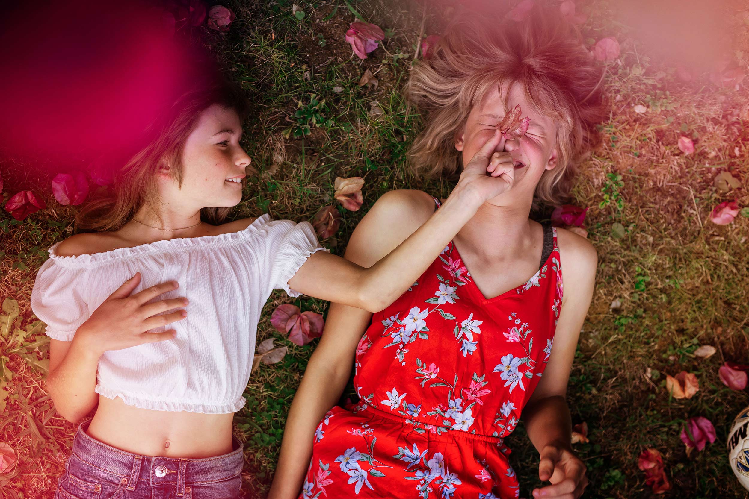 teenage girls laying on ground pinching nose