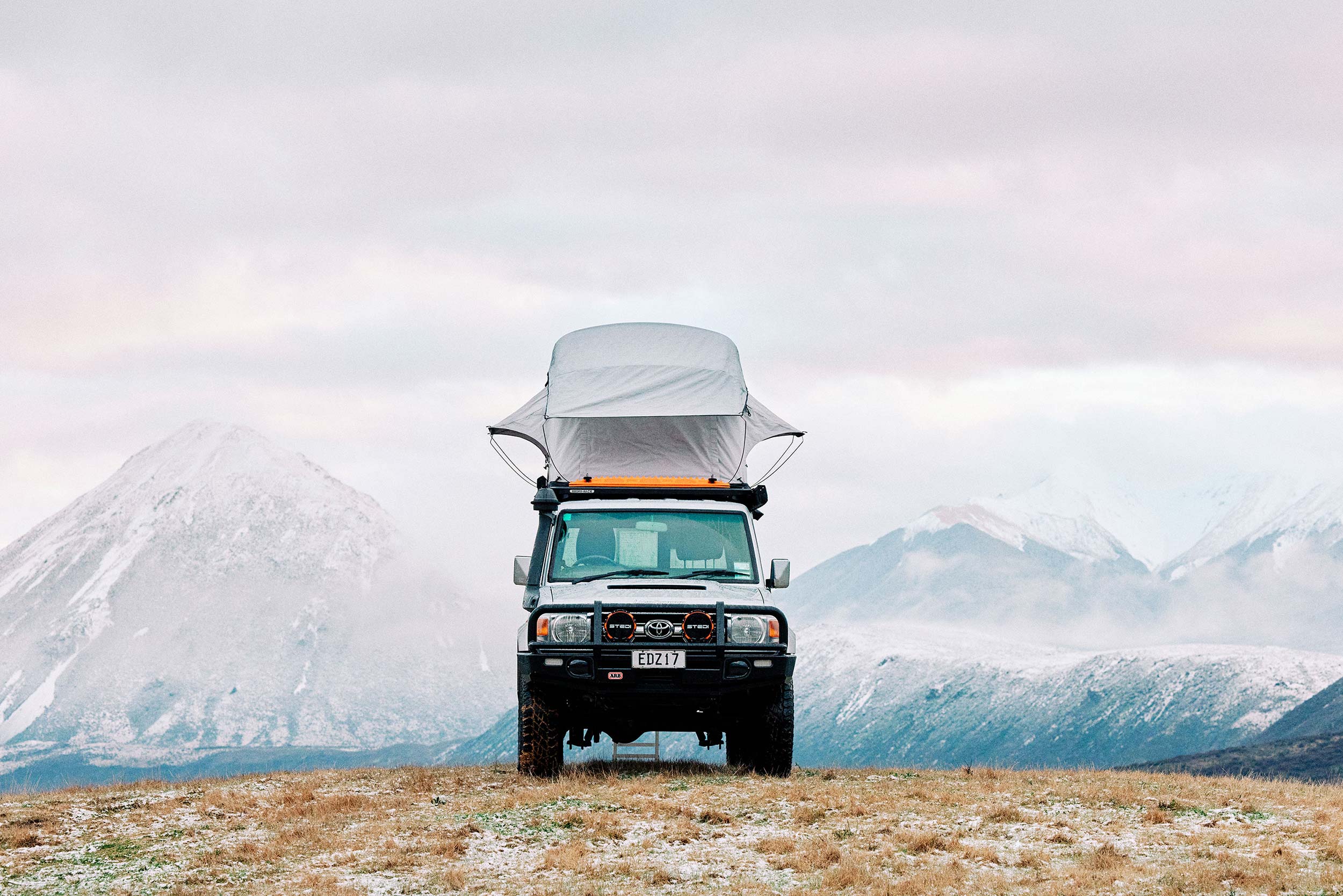Toyota on hill snow mountains poptop on roof Swanndri FlockHill